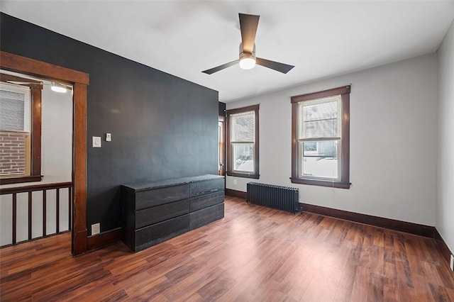 bedroom with baseboards, ceiling fan, dark wood-type flooring, and radiator