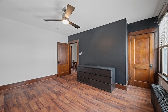 spare room with a wealth of natural light, baseboards, and wood finished floors