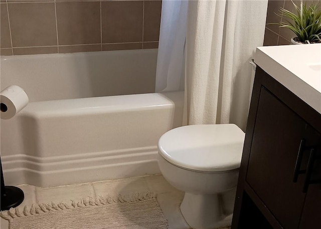 full bathroom featuring toilet, shower / bath combo with shower curtain, and vanity