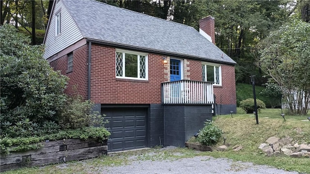 view of front of home featuring a garage, brick siding, a chimney, and a shingled roof