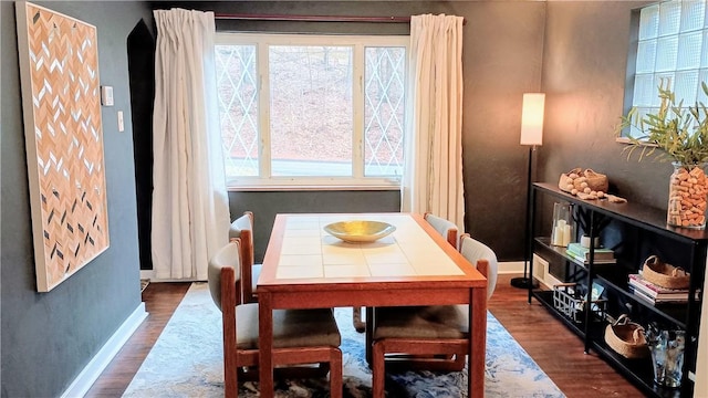 dining area with dark wood finished floors and baseboards