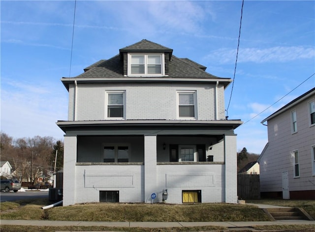 traditional style home with brick siding, roof with shingles, a porch, and cooling unit