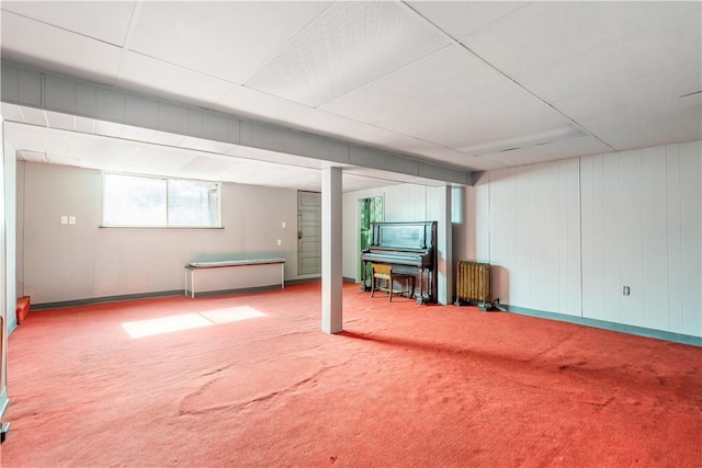 basement featuring radiator heating unit and carpet flooring