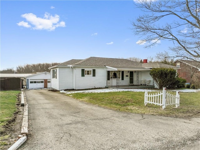 ranch-style home with an outbuilding, a detached garage, a porch, fence, and driveway