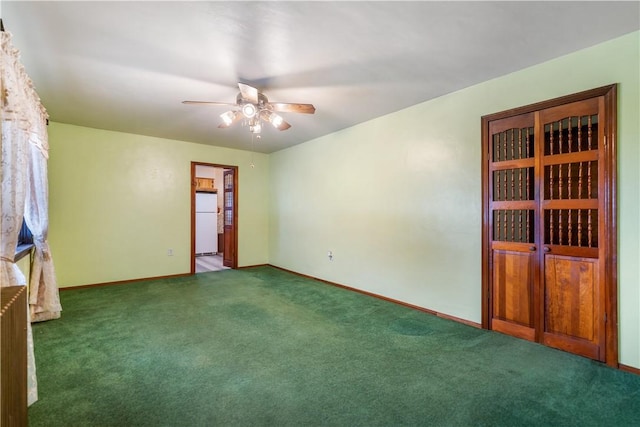 unfurnished room with dark carpet, baseboards, and ceiling fan