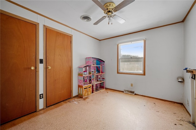 interior space featuring baseboards, visible vents, a ceiling fan, light colored carpet, and crown molding