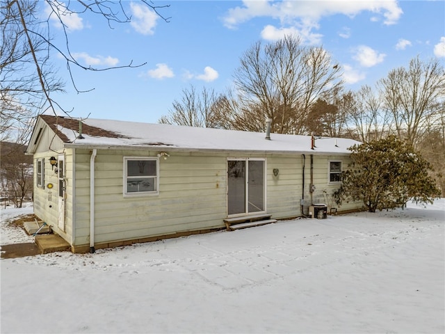 snow covered house featuring entry steps