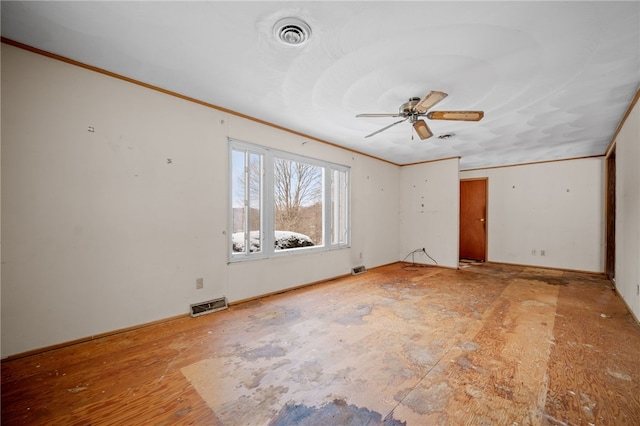 empty room featuring a ceiling fan, visible vents, and crown molding