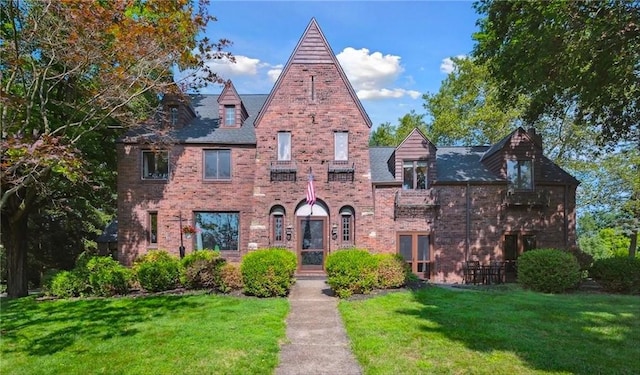 tudor house with a front lawn and brick siding