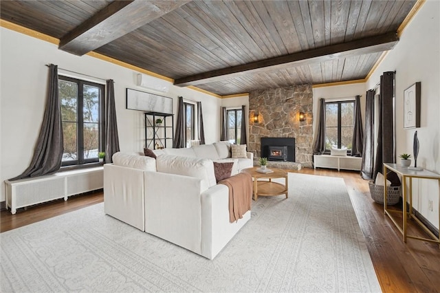 living room featuring radiator, wooden ceiling, a wall unit AC, wood finished floors, and a fireplace