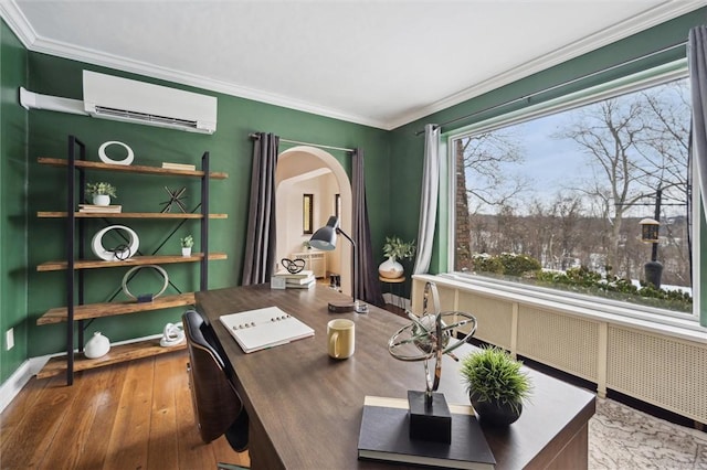 office space featuring radiator heating unit, ornamental molding, wood finished floors, a wall mounted air conditioner, and baseboards