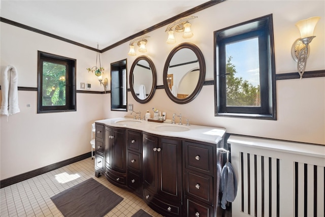 full bathroom with crown molding, a sink, baseboards, and double vanity