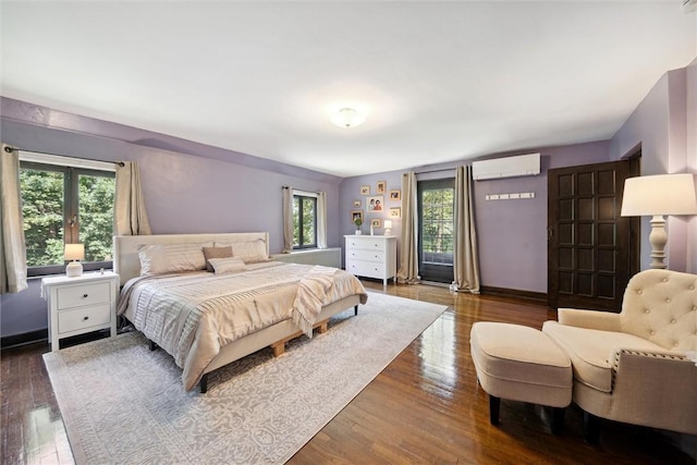 bedroom featuring a wall unit AC, dark wood finished floors, and baseboards