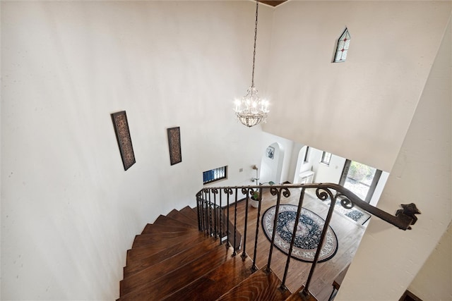 staircase featuring a chandelier and wood finished floors