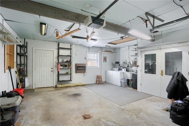 garage with a garage door opener, heating unit, and washer and dryer