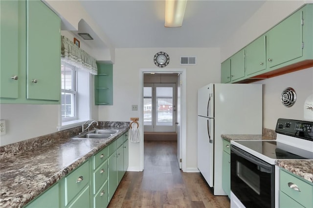 kitchen with range with electric cooktop, a sink, a wealth of natural light, dark countertops, and green cabinetry