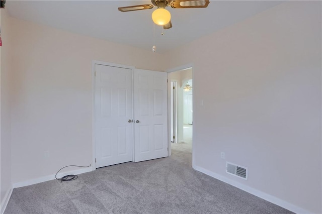 unfurnished bedroom with ceiling fan, light colored carpet, visible vents, baseboards, and a closet