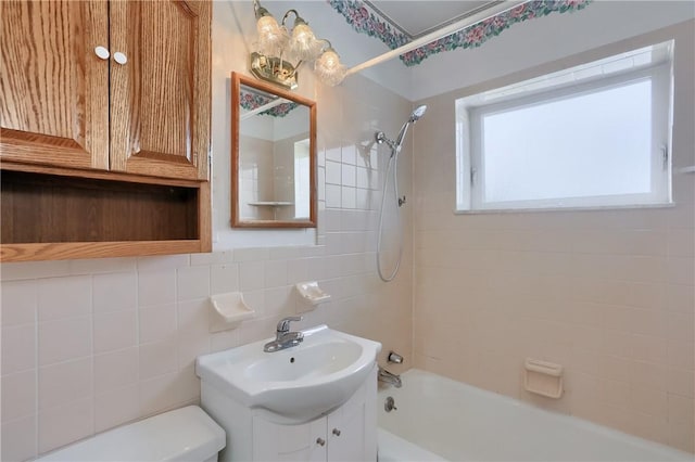 bathroom with toilet, backsplash, tile walls, and shower / bathing tub combination