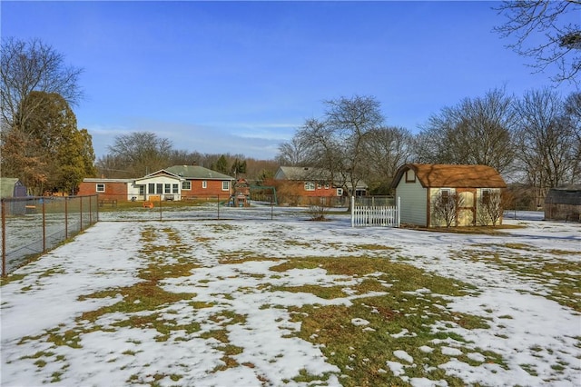 yard covered in snow featuring fence and a playground