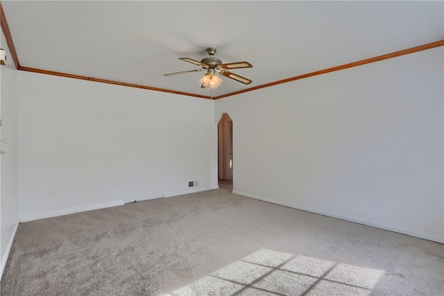 unfurnished room featuring visible vents, arched walkways, light colored carpet, ceiling fan, and ornamental molding