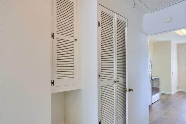 hall featuring light wood-style flooring and baseboards