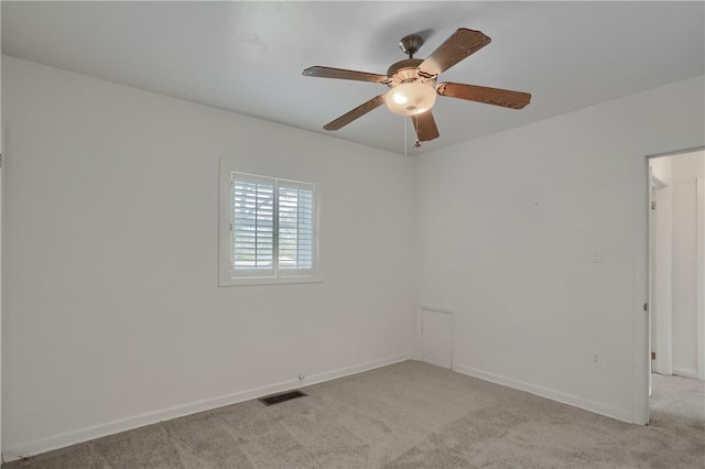 empty room featuring a ceiling fan, visible vents, light carpet, and baseboards