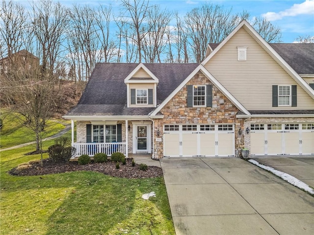 view of front facade featuring a porch, an attached garage, concrete driveway, stone siding, and a front lawn