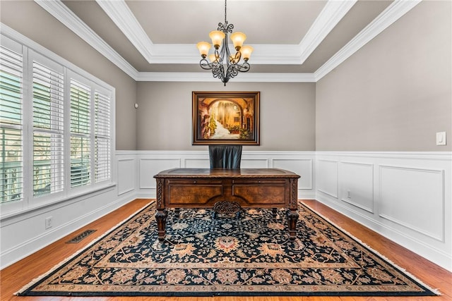 office featuring a chandelier, a raised ceiling, wood finished floors, and visible vents