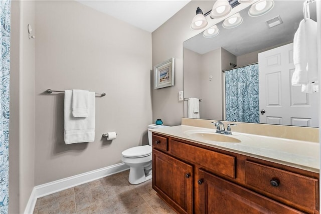 bathroom featuring toilet, visible vents, vanity, baseboards, and tile patterned floors