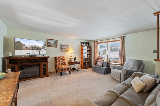 living area with light colored carpet and a glass covered fireplace