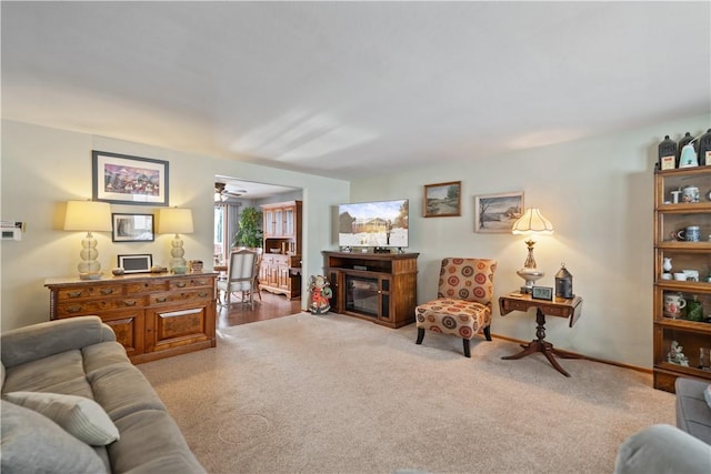 living room with carpet floors and a glass covered fireplace