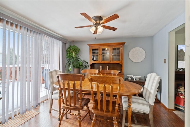 dining space featuring dark wood-type flooring, plenty of natural light, baseboards, and ceiling fan