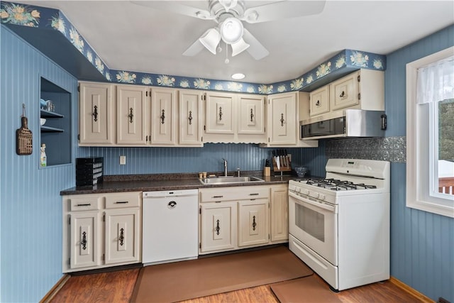 kitchen featuring dark countertops, white appliances, a sink, and extractor fan