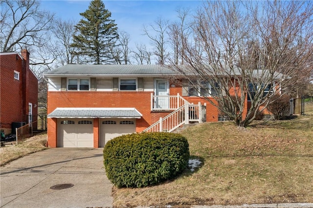 view of front of property with a front yard, concrete driveway, brick siding, and an attached garage