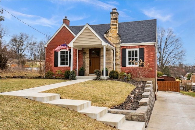 view of front of property featuring brick siding, a front lawn, and a shingled roof