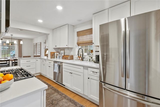 kitchen with white cabinets, stainless steel appliances, and light countertops