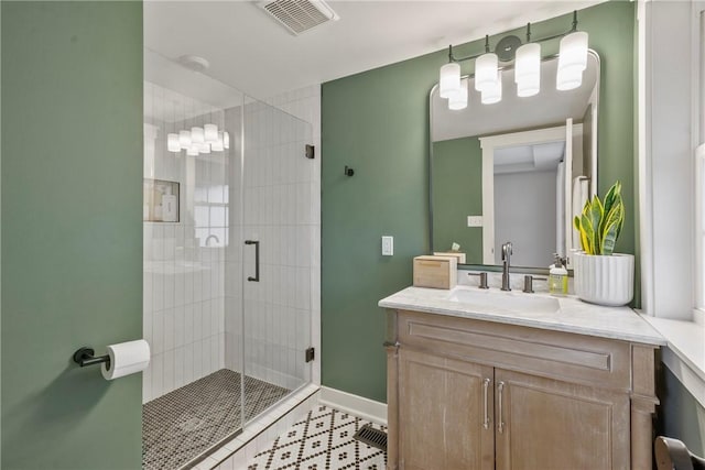 bathroom with visible vents, a stall shower, vanity, baseboards, and tile patterned floors