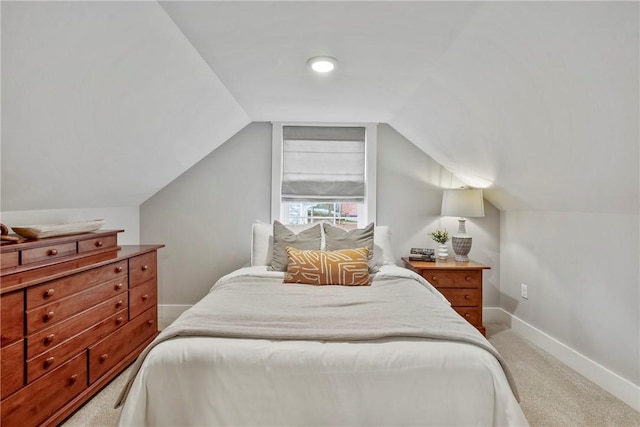 carpeted bedroom featuring lofted ceiling and baseboards