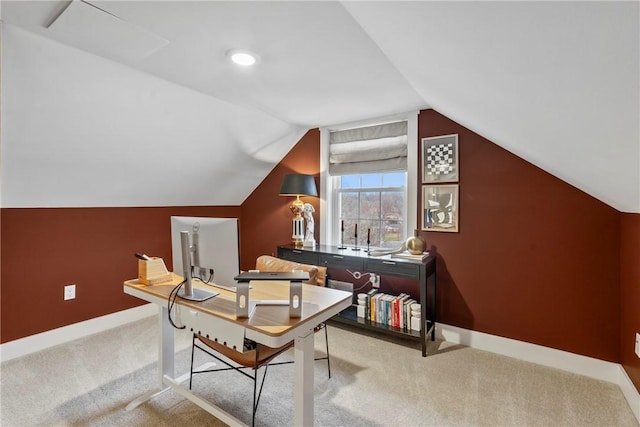 home office with lofted ceiling, light carpet, and baseboards