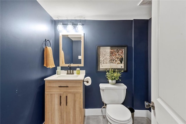 half bath with toilet, baseboards, visible vents, and vanity