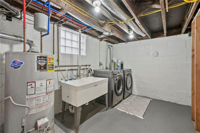 washroom featuring a sink, laundry area, washer and dryer, and gas water heater