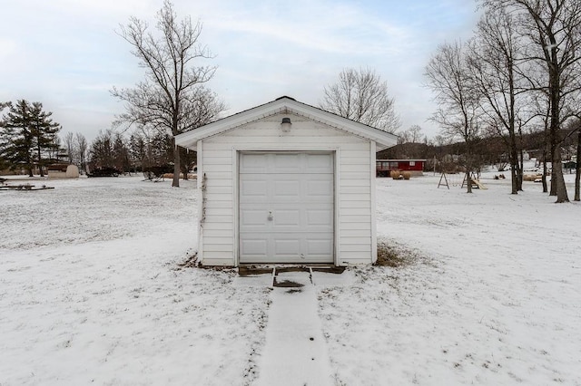 snow covered garage featuring a detached garage