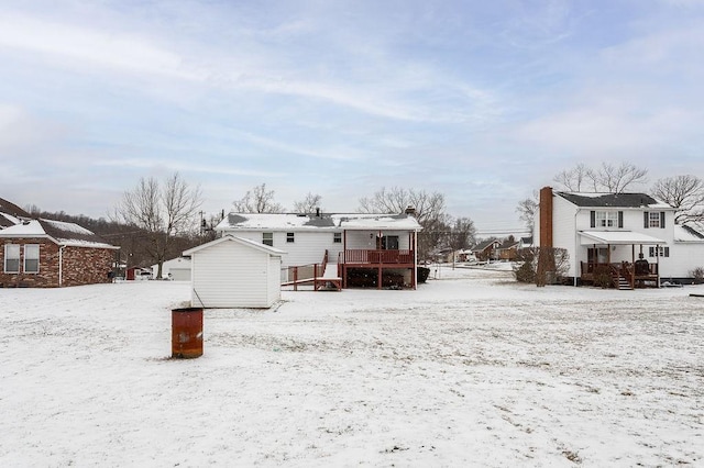 snow covered house featuring a garage, a residential view, and a deck