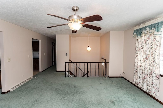 carpeted spare room featuring a textured ceiling, a baseboard radiator, and baseboards