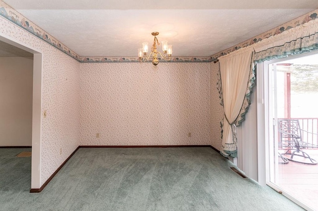 spare room with carpet, a notable chandelier, baseboards, and wallpapered walls