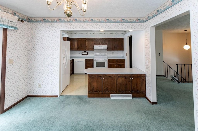 kitchen with white appliances, light countertops, under cabinet range hood, and wallpapered walls