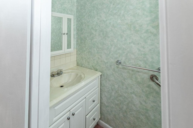 bathroom with wallpapered walls and vanity