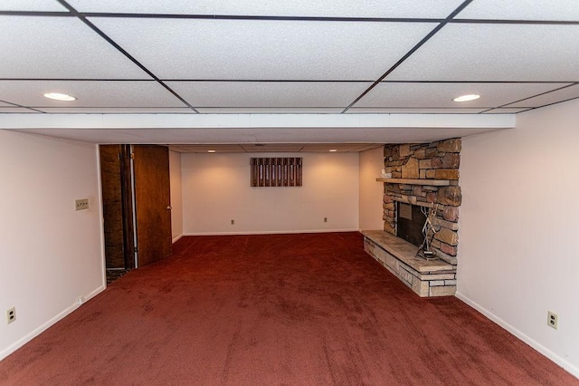 unfurnished living room with carpet floors, a paneled ceiling, a fireplace, and baseboards