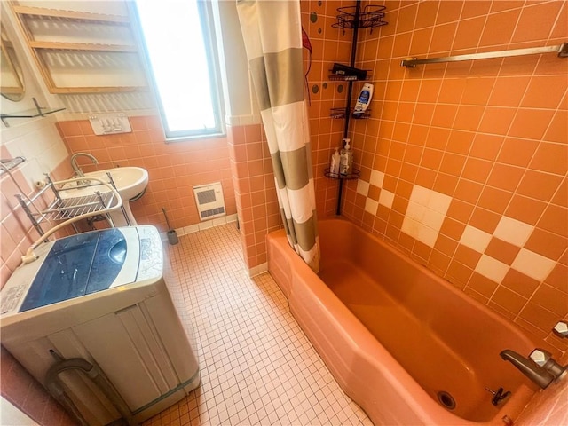 bathroom with tile walls, toilet, shower / bath combo, a sink, and tile patterned floors