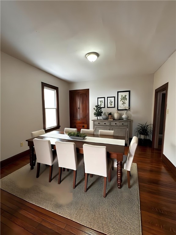 dining space with dark wood-type flooring and baseboards